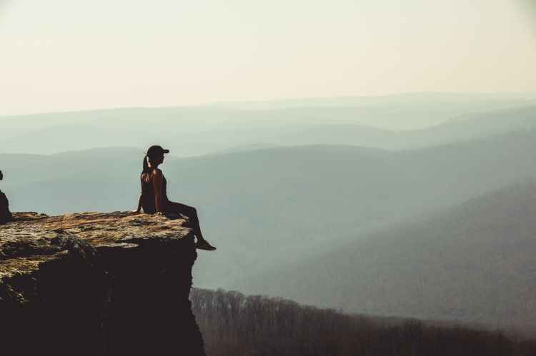woman sitting on cliff